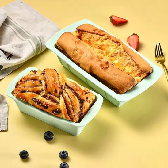 Moule à gâteau silicone PâtissiPro vert avec deux gâteaux cuit sur fond jaune avec petits fruits