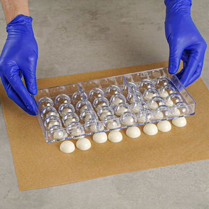 Moule à chocolat transparent avec chocolat blanc sur papier brun