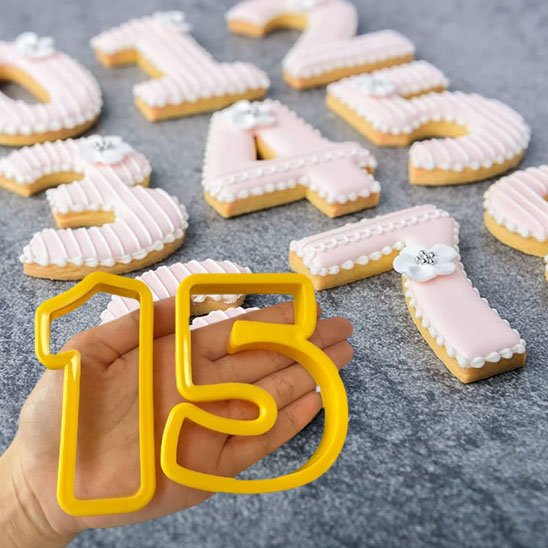 Moule number cake de couleur jaune avec le chiffre 1 et 5 dans la main