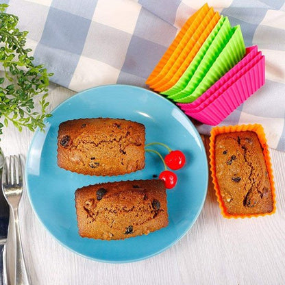 Moule à muffin PatissiPro de couleur varié avec 2 pâtisserie dans assiette bleu et 2 cerises