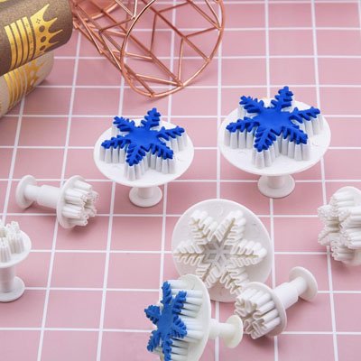 Emporte pièces Noël Festivo avec flocons bleu marin sur table rose