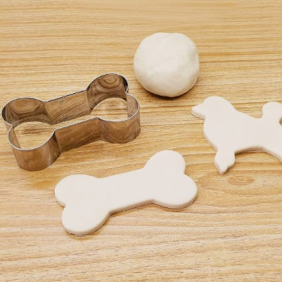 Emporte pièce PawTreats sur planche de bois avec deux biscuits