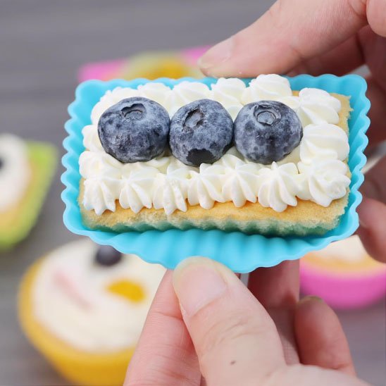 Moule à muffin PatissiPro bleu avec pâtisserie garni de crème fouetté et bleuets