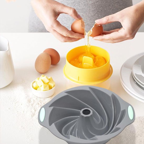 Moule à gâteau en silicone design spiralé  en préparation avec œufs et beurre